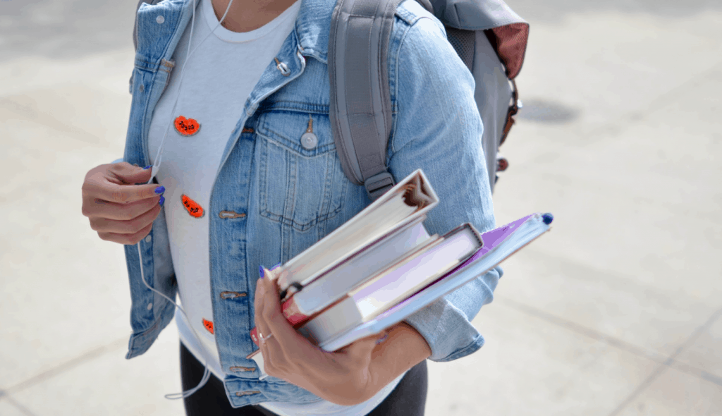 A College Student Holding Books In Hand